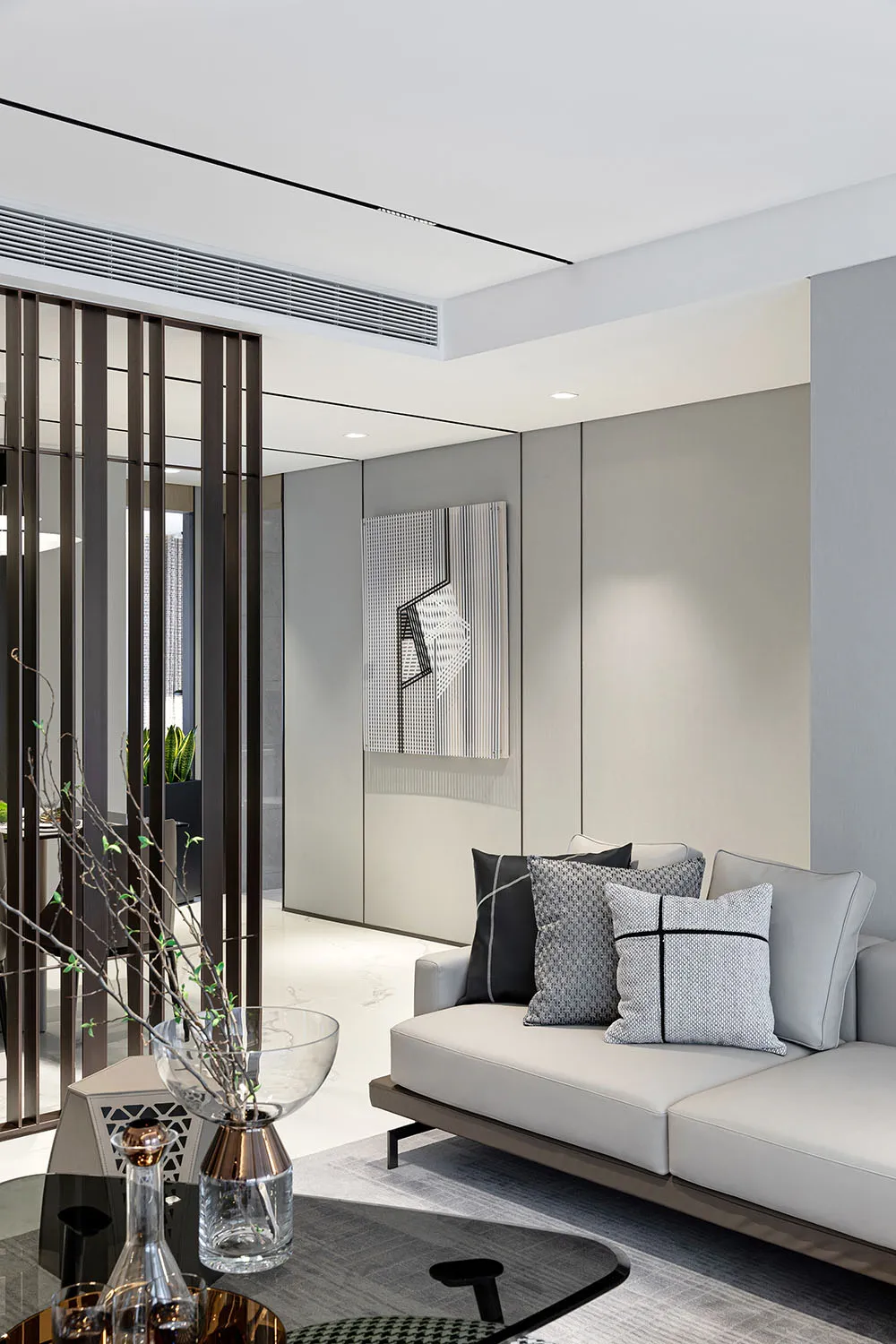 A modern living room featuring a metal frame, glass panels, and fabric seating.