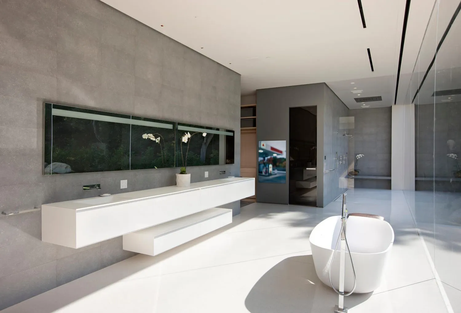 Modern minimalist bathroom with concrete walls, white floor, white bathtub, and large window with potted plant.