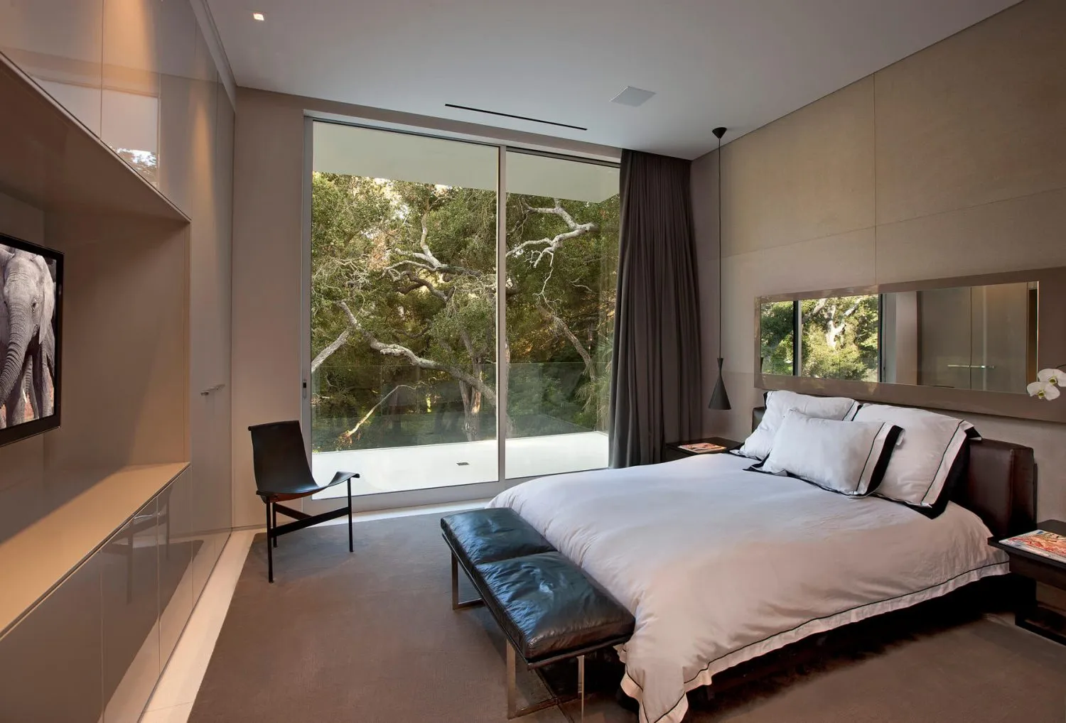 A modern bedroom featuring fabric, leather, and glass materials.