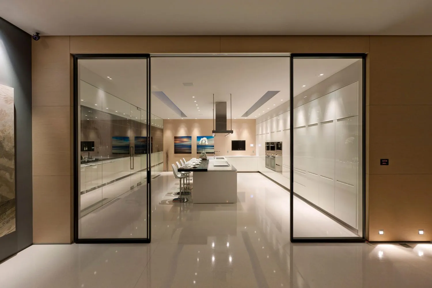 Modern residential kitchen featuring white marble countertops and glass cabinets