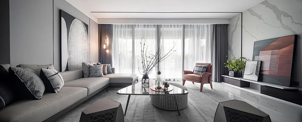 A modern minimalist living room with a fabric sofa, glass table, and minimalist decor.