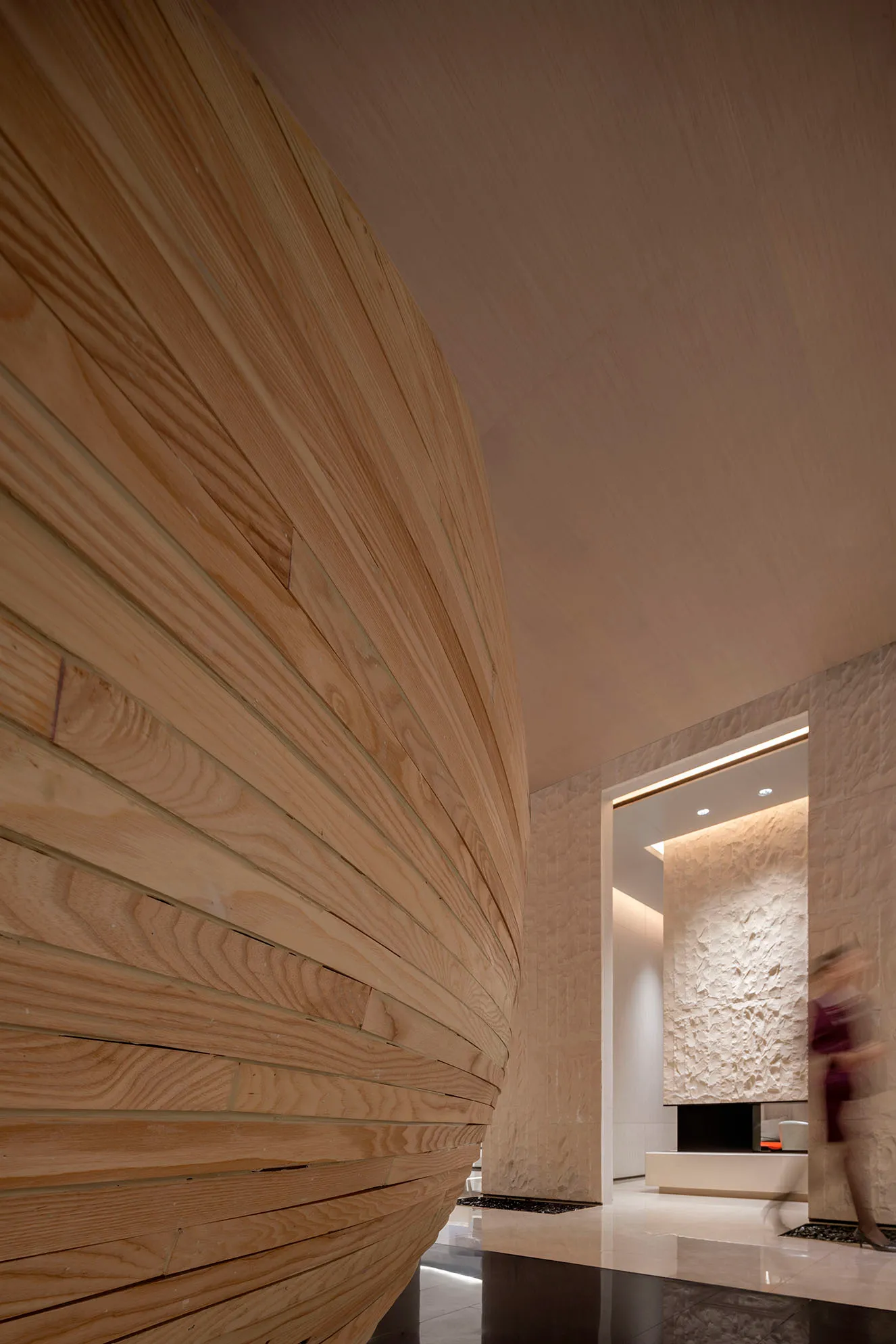 Modern lobby interior with textured wooden walls and a sleek, contemporary design.