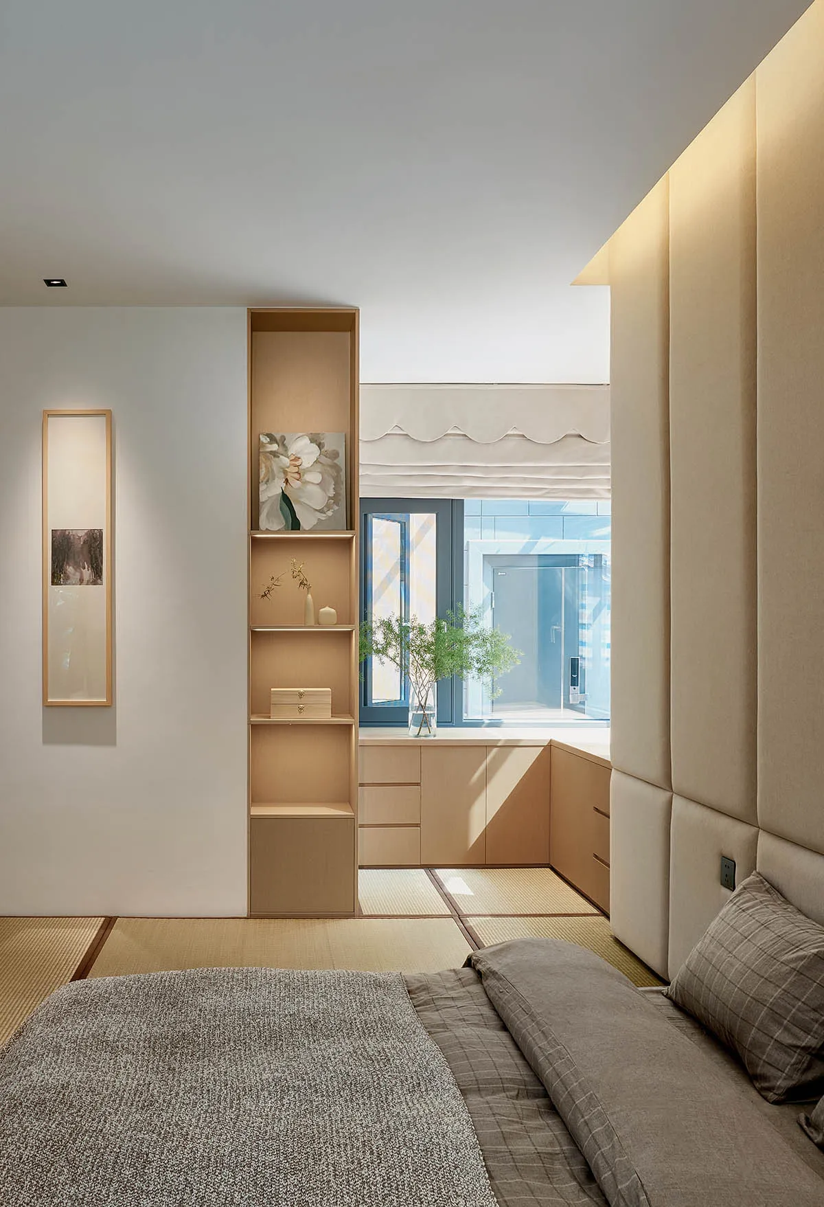 A minimalist bedroom with a storage system, tatami mats, and soft lighting