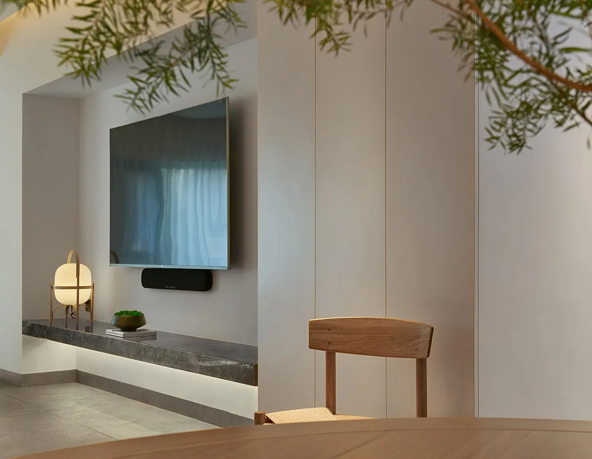 Modern minimalist living room featuring a wooden frame wall, glass window, and metal accents.