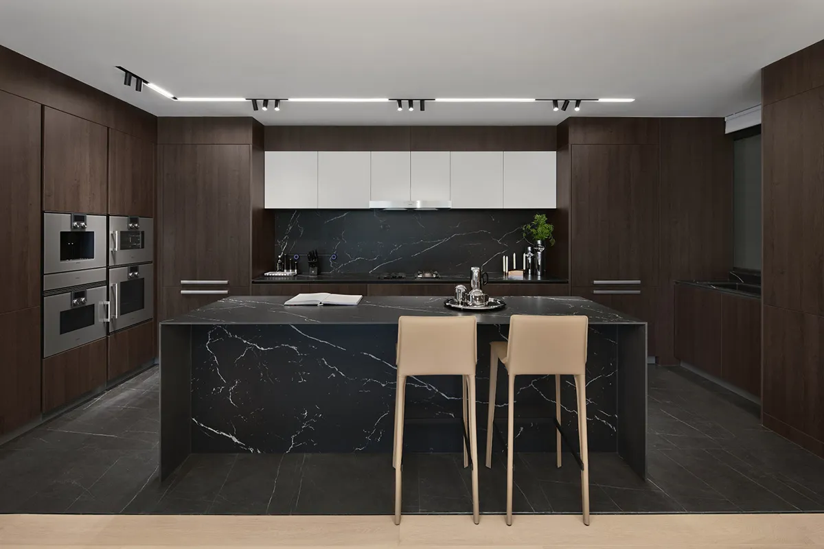 Modern residential kitchen featuring black granite countertops and marble furniture.
