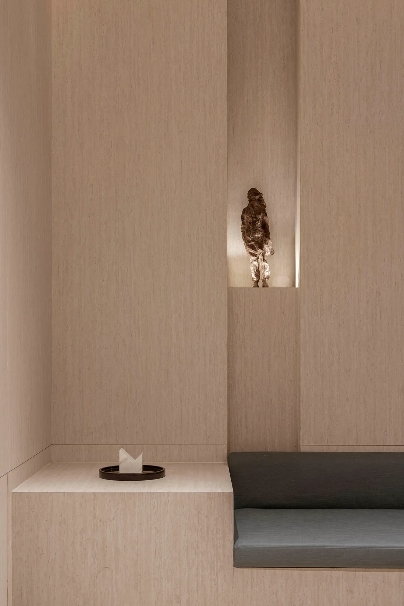 A minimalist lounge area featuring textured wood materials and sleek, integrated seating designed for comfort and style.