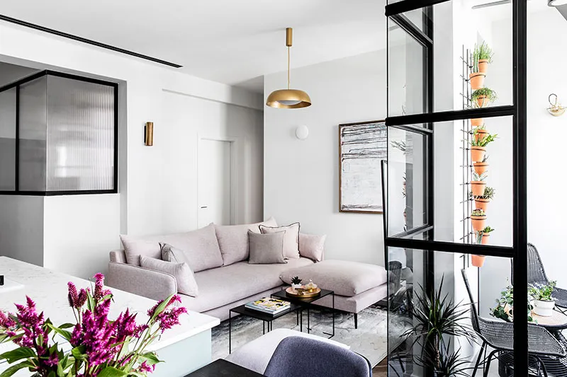 Modern living room featuring a pink sectional sofa, a marble coffee table, and glass windows.