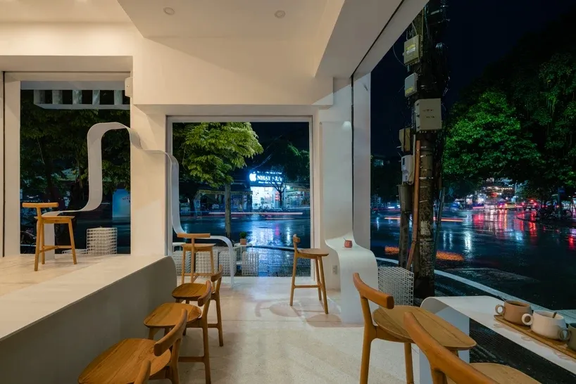 Modern retail shop interior with wooden furniture and large windows.