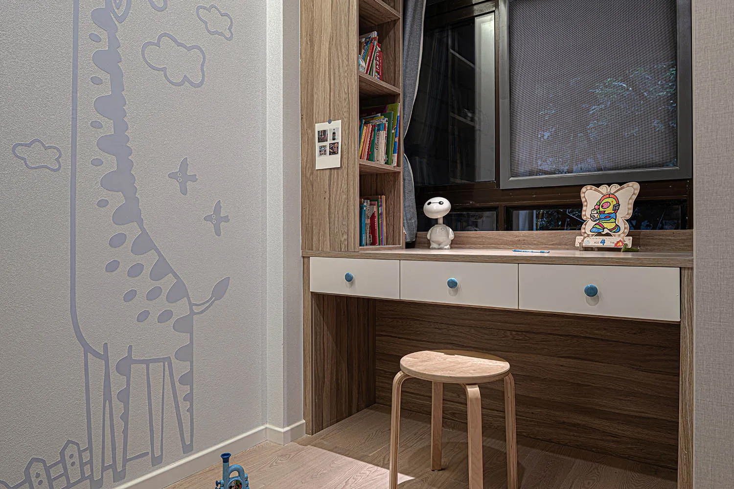 A well-designed children's room featuring wooden furniture and a cozy reading nook.