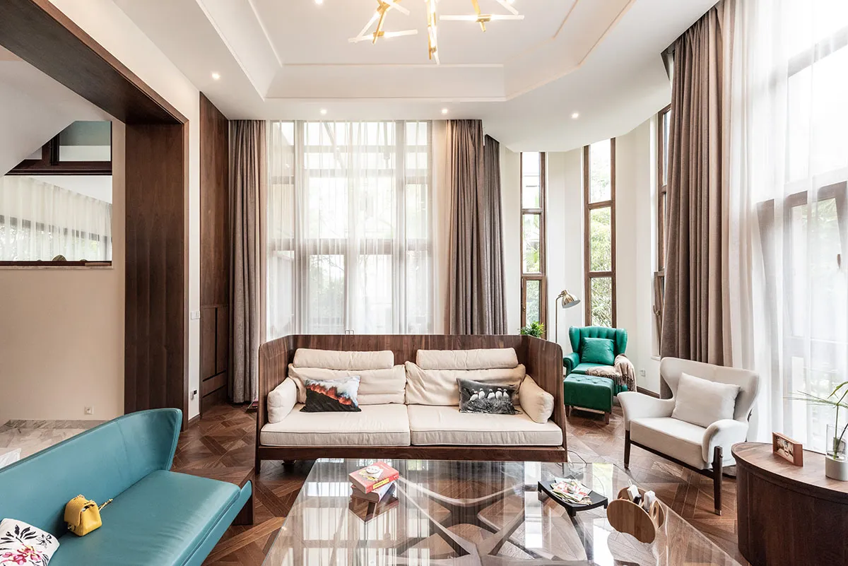 Modern living room with wooden furniture, leather accents, and glass coffee table.