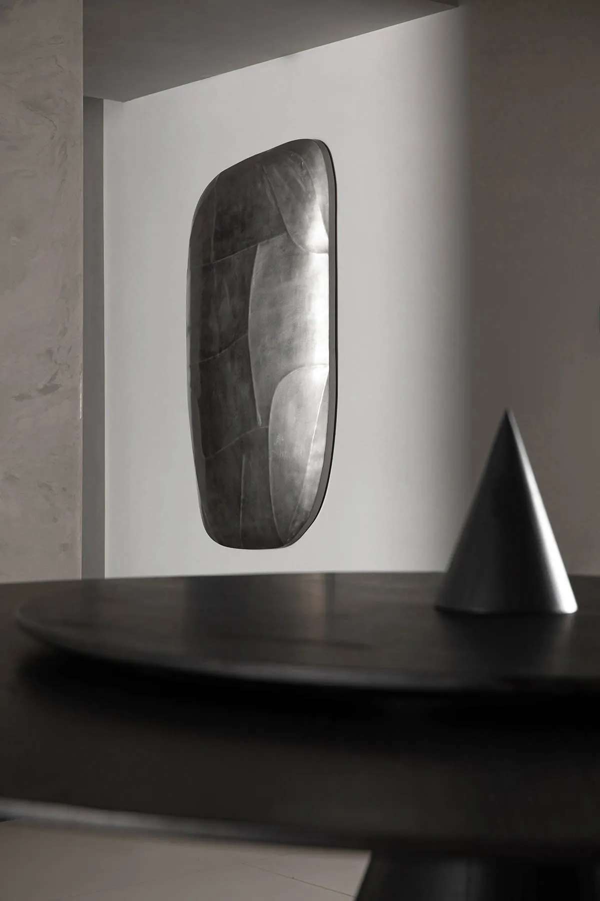 A metallic, minimalist decorative object with a futuristic design.