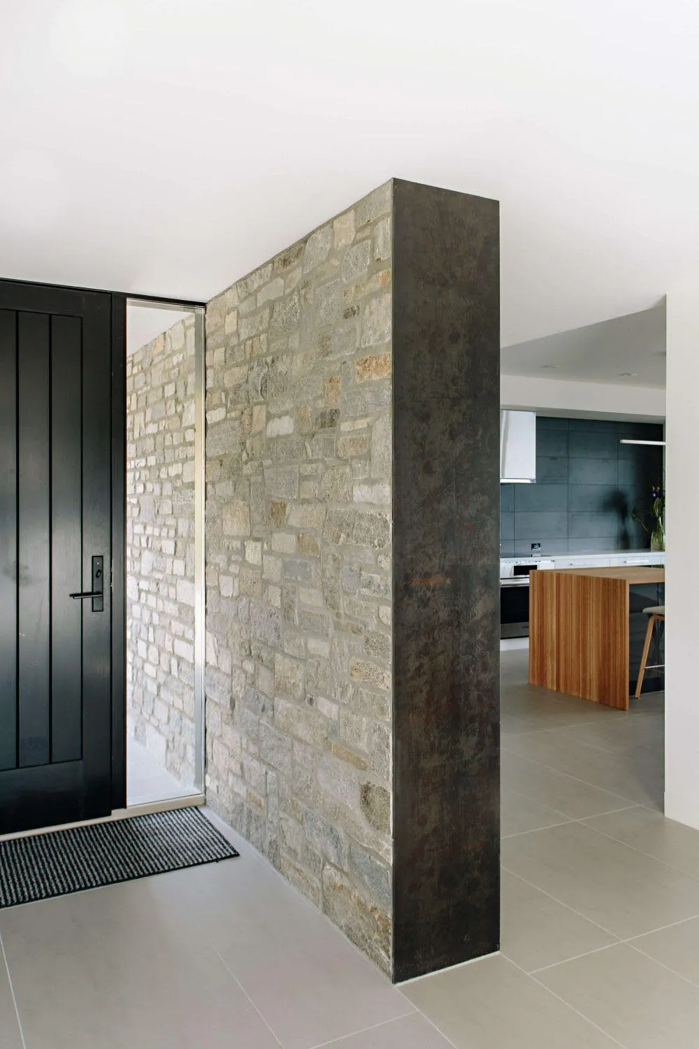 A minimalist interior featuring a stone wall