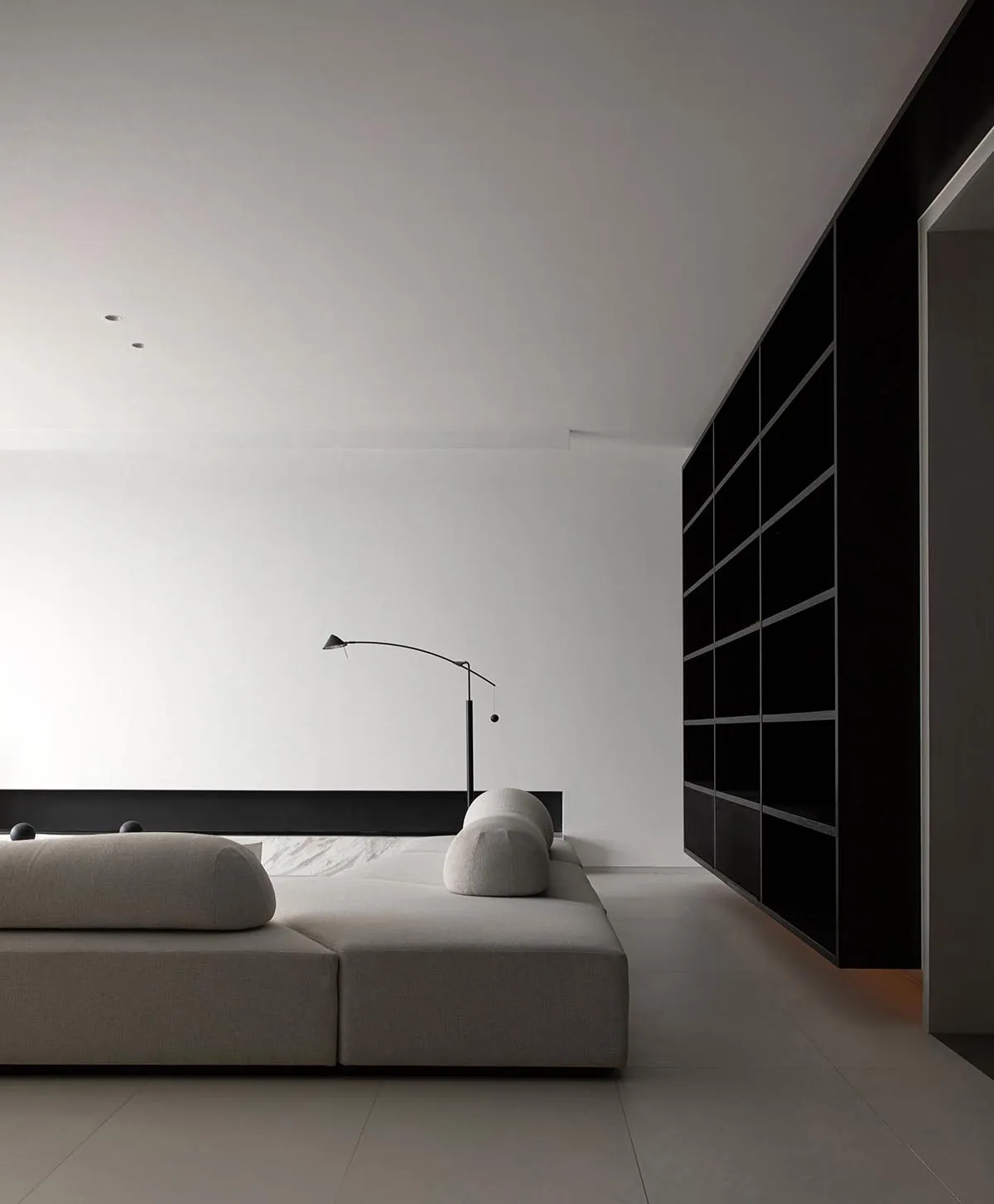 Modern living room with minimalist design, white walls, and a upholstered sofa.