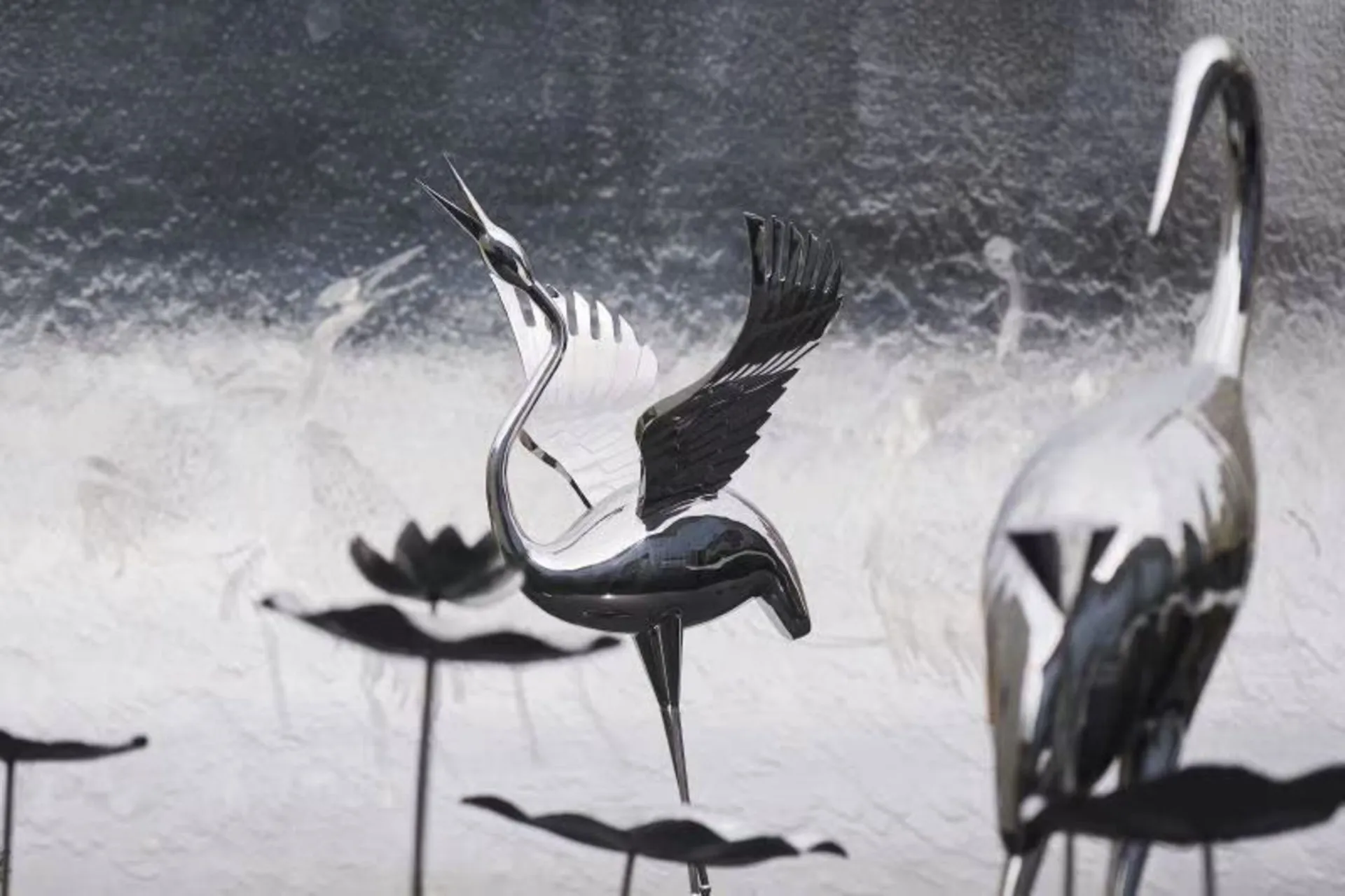 Metal bird sculptures with reflective surfaces.