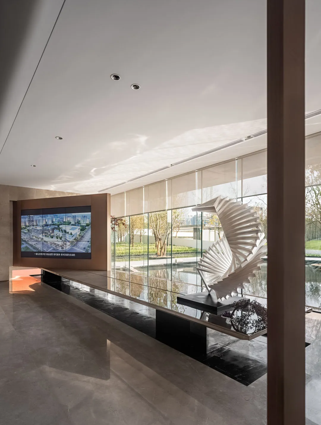 A modern lobby featuring glass, steel, and marble materials.