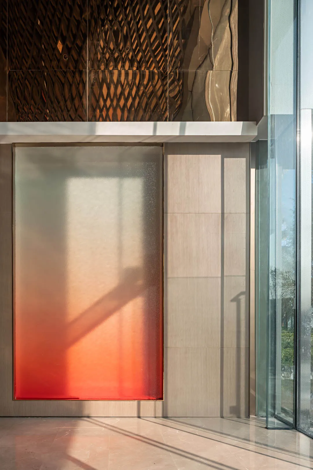 A modern lobby with a glass window featuring a red gradient shadow.