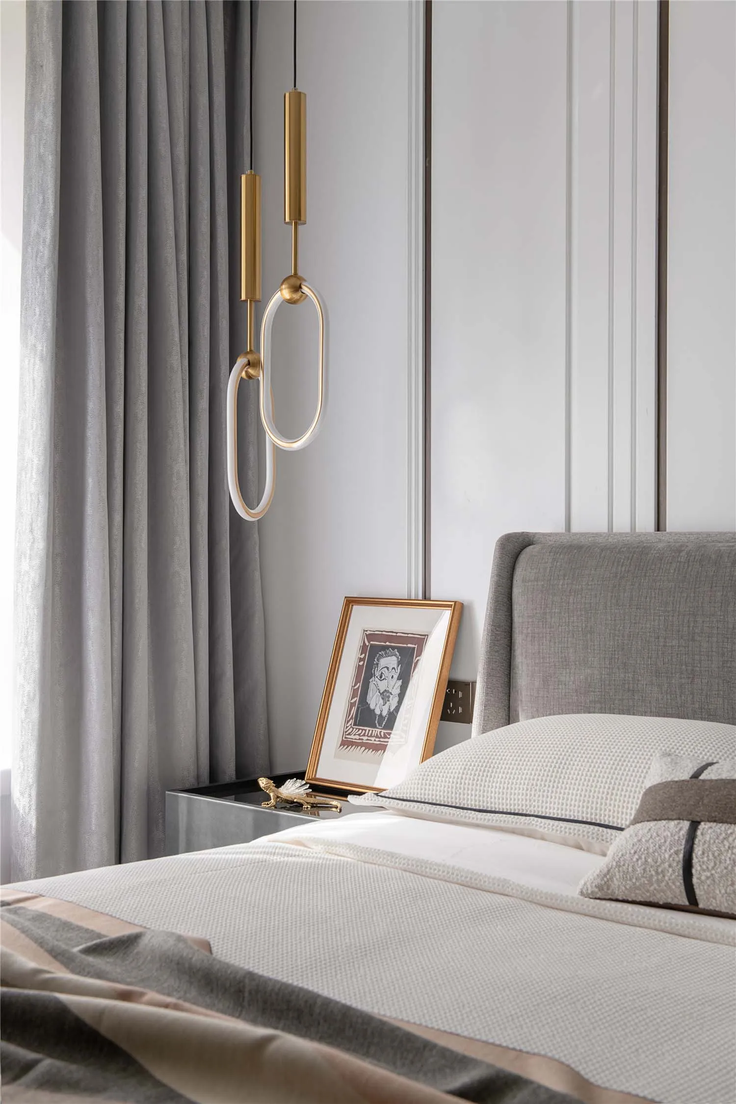 A minimalist bedroom showcasing a neatly made bed with modern lighting and decorative elements.