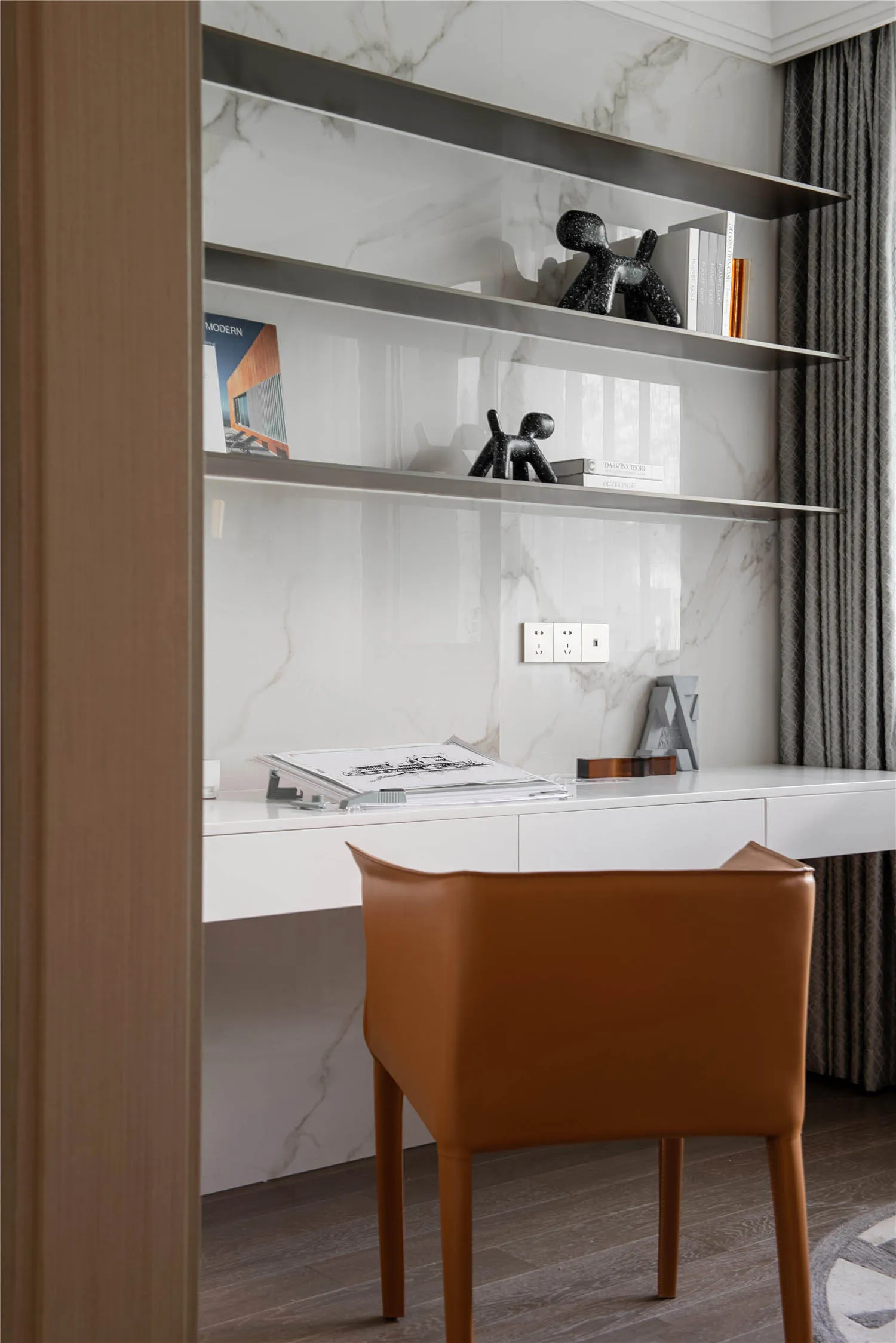 Modern office space featuring a desk made of marble and a chair upholstered in leather.
