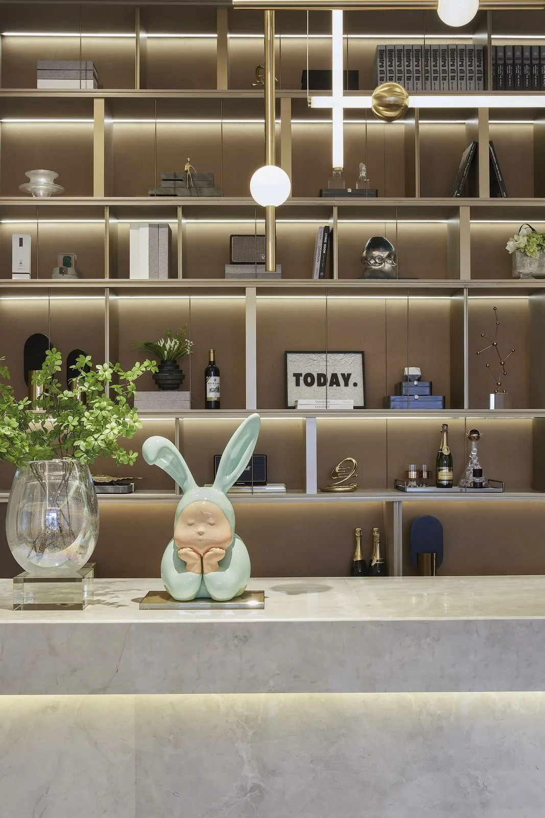 A modern reception desk made of marble with a rabbit figurine on top and decorative items arranged on the shelves in the back