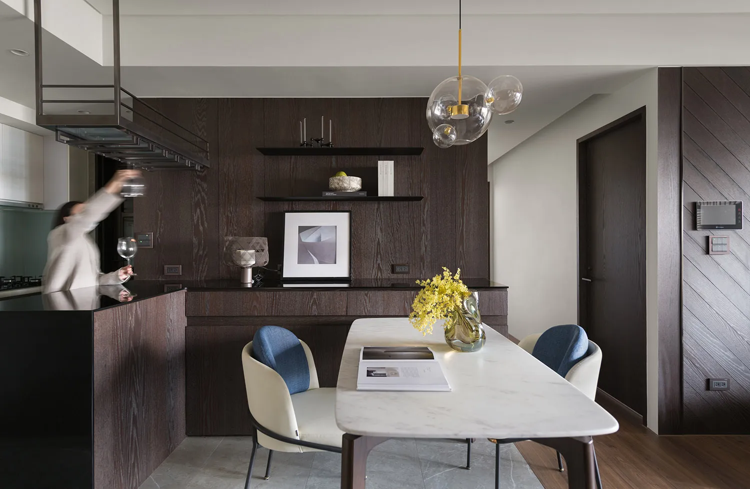 A modern residential kitchen featuring a marble countertop, wooden cabinets, and a stainless steel kitchen island.