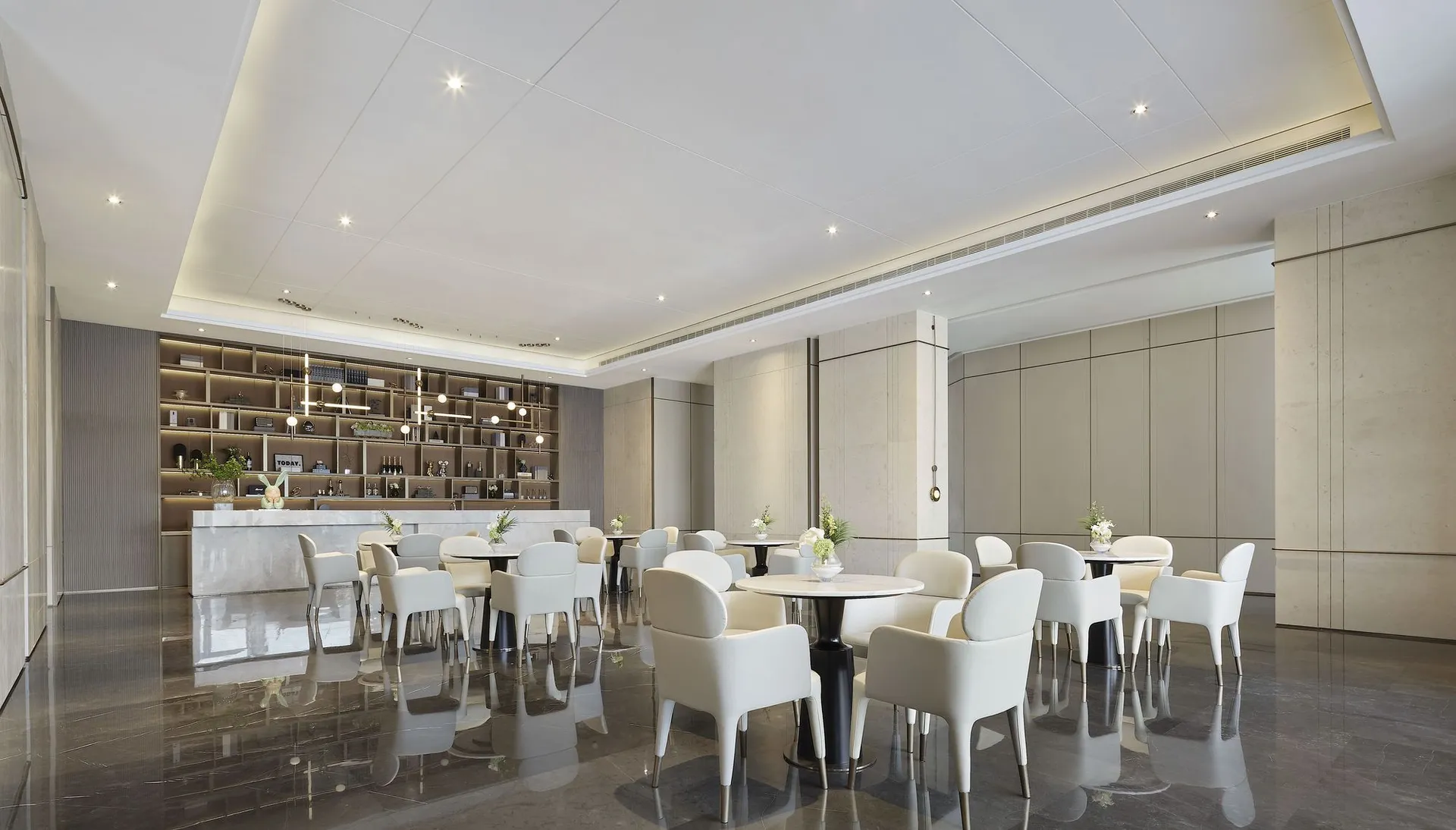 A modern restaurant interior featuring elegant white marble finishes and sleek white furniture.