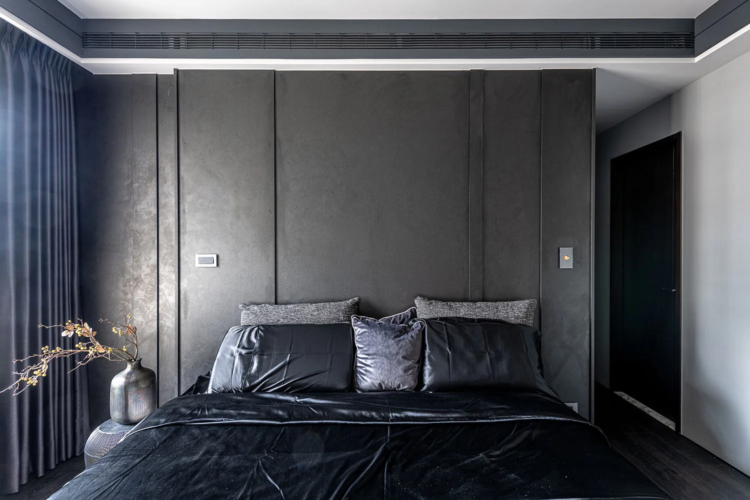 Modern bedroom featuring upholstered furniture with leather and fabric finishes.