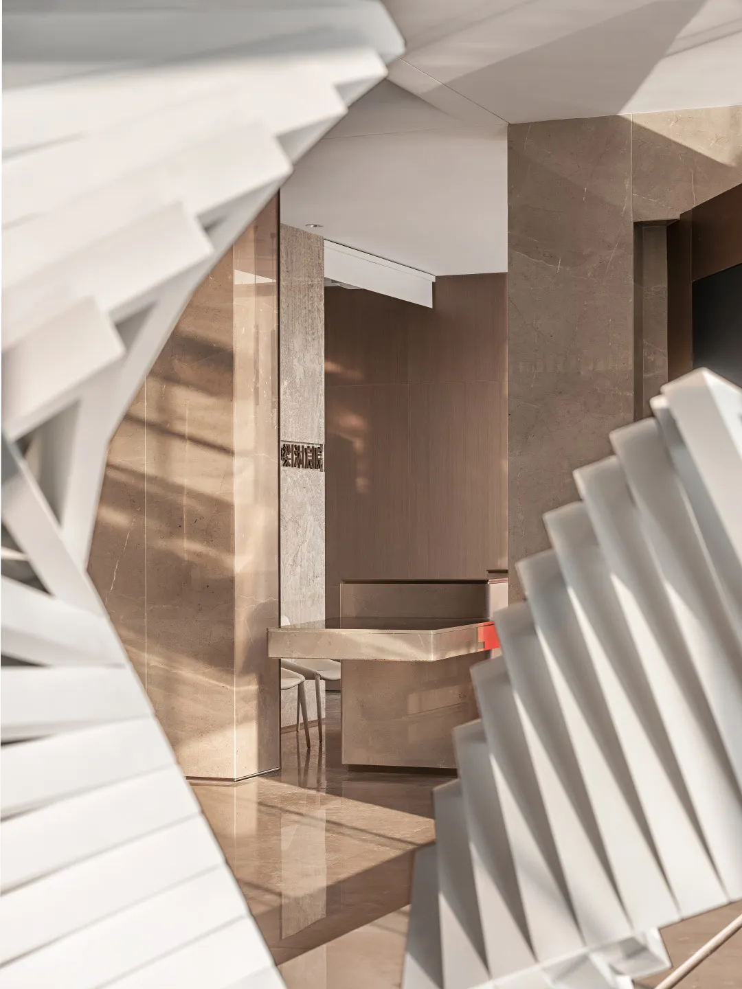 Modern office reception area with marble flooring and walls.