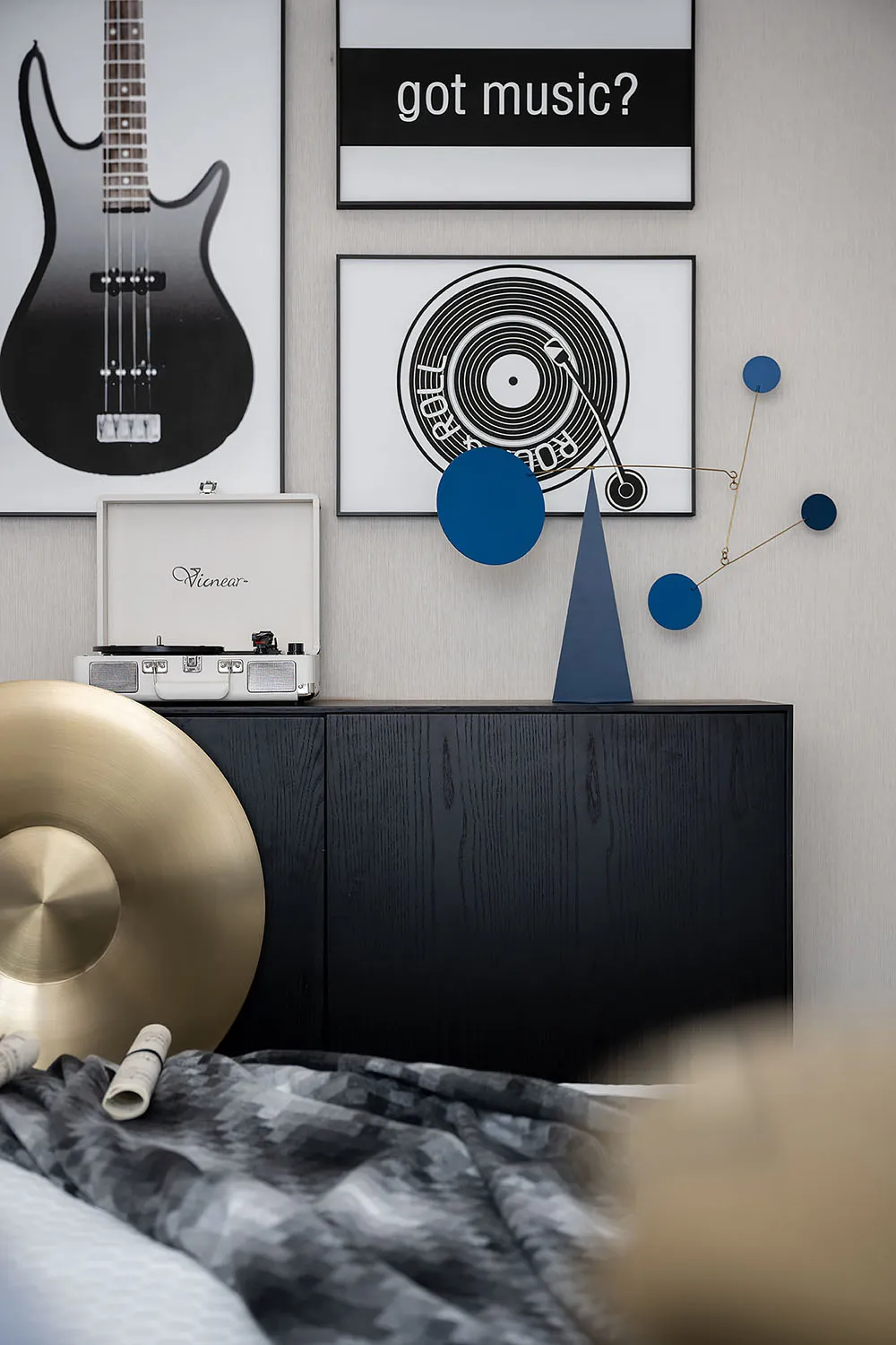 A bedroom featuring a record player, guitar, and various musical decor elements in black, white, and blue colors.