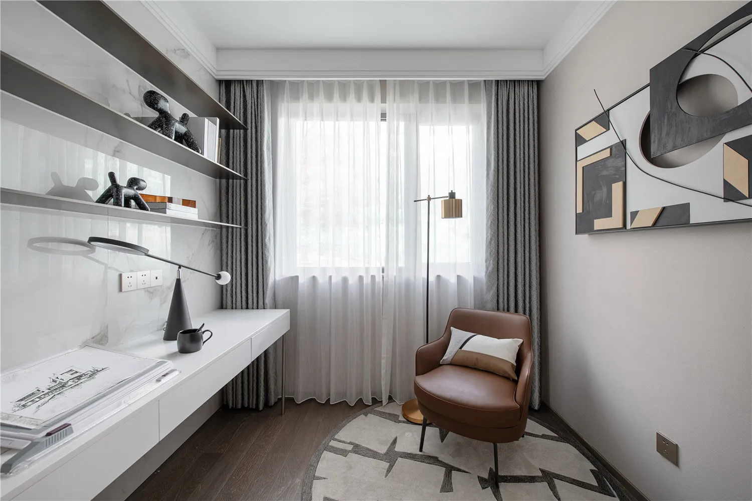 A modern home office with minimalist furniture and a comfortable armchair.