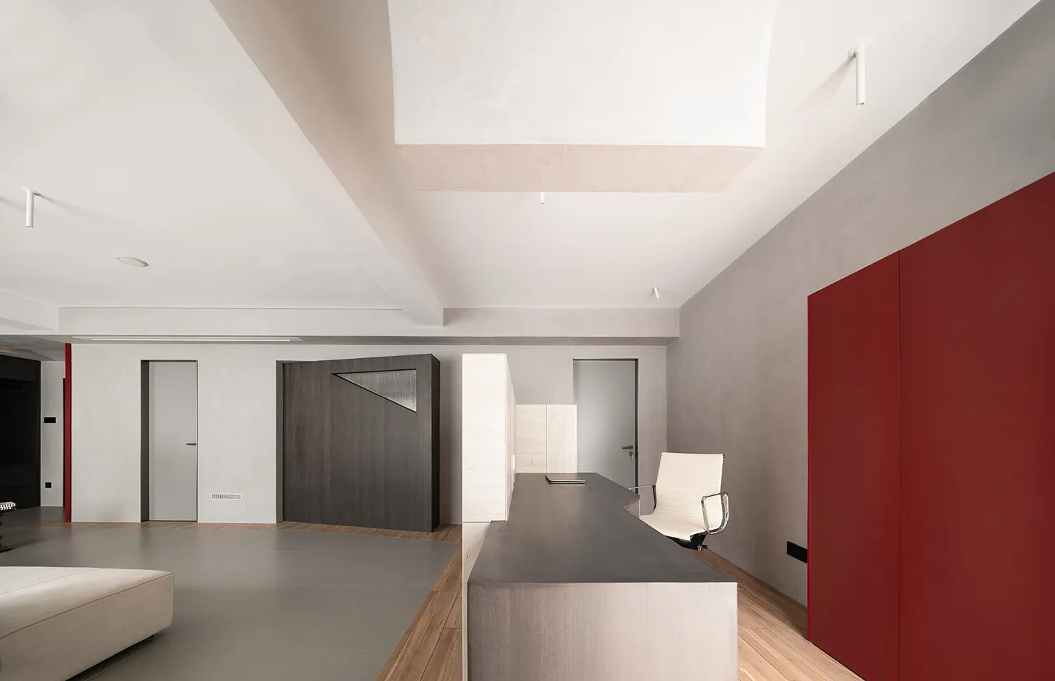 A modern industrial office space featuring exposed concrete floors and walls.