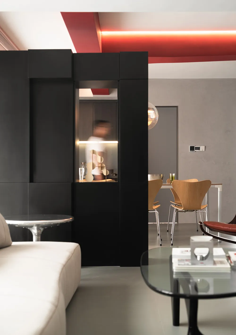 A modern living room featuring sleek furniture, a minimalist design, and a mix of metal, wood, and glass materials.