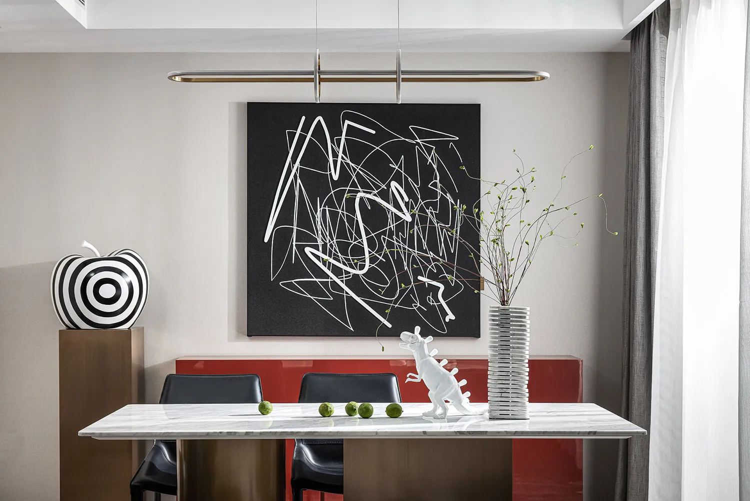 A contemporary dining room featuring a glass table with green apples and a white toy dinosaur on it, with a black and white a