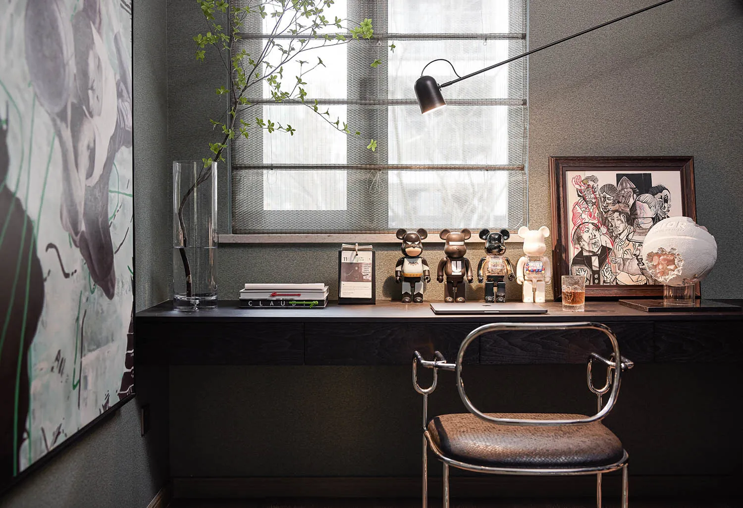 A modern home office with a desk, chair, and various decorative items.