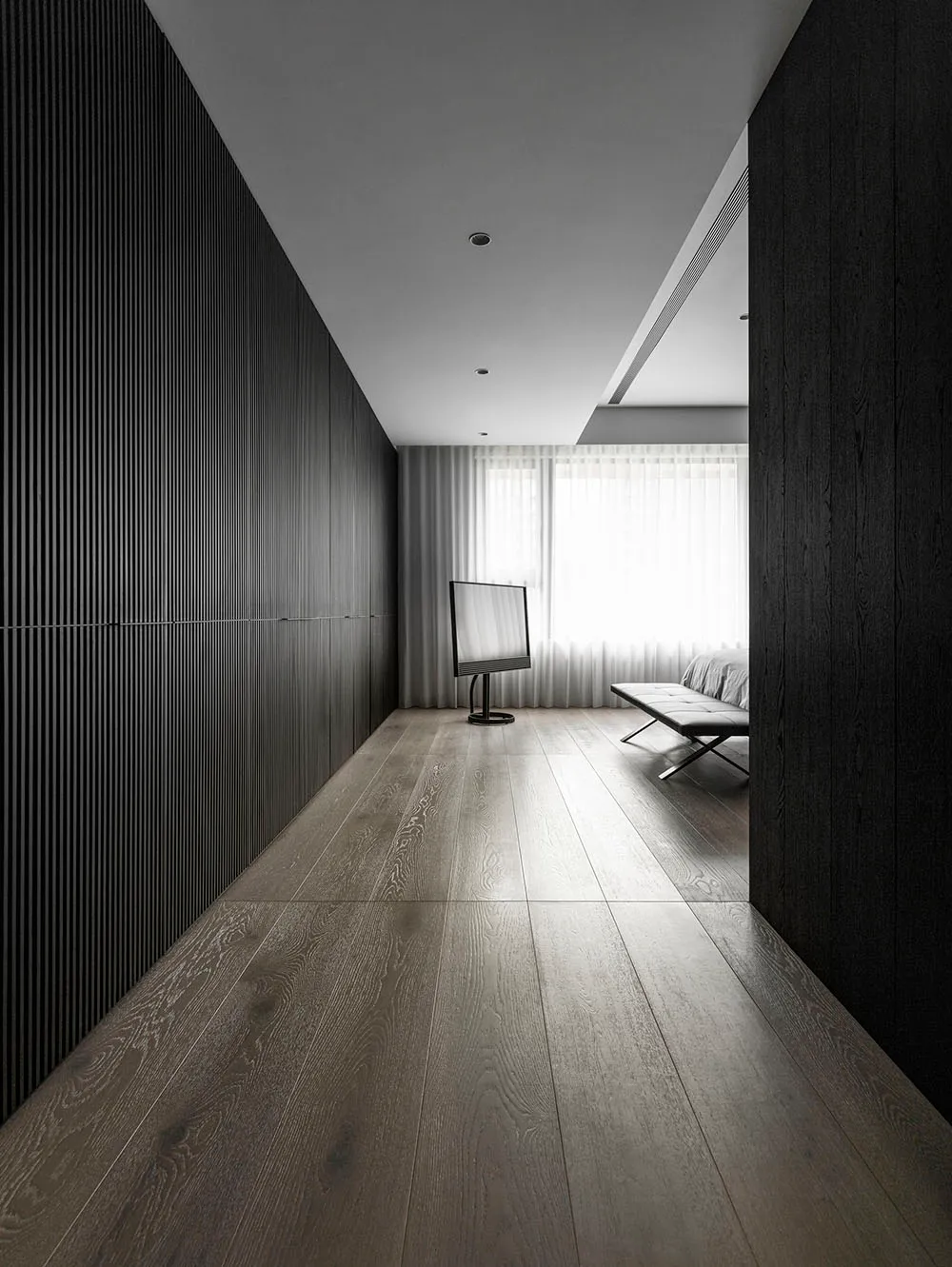 Modern minimalist bedroom with dark wooden walls, white curtains, and a sleek, contemporary bench and TV.