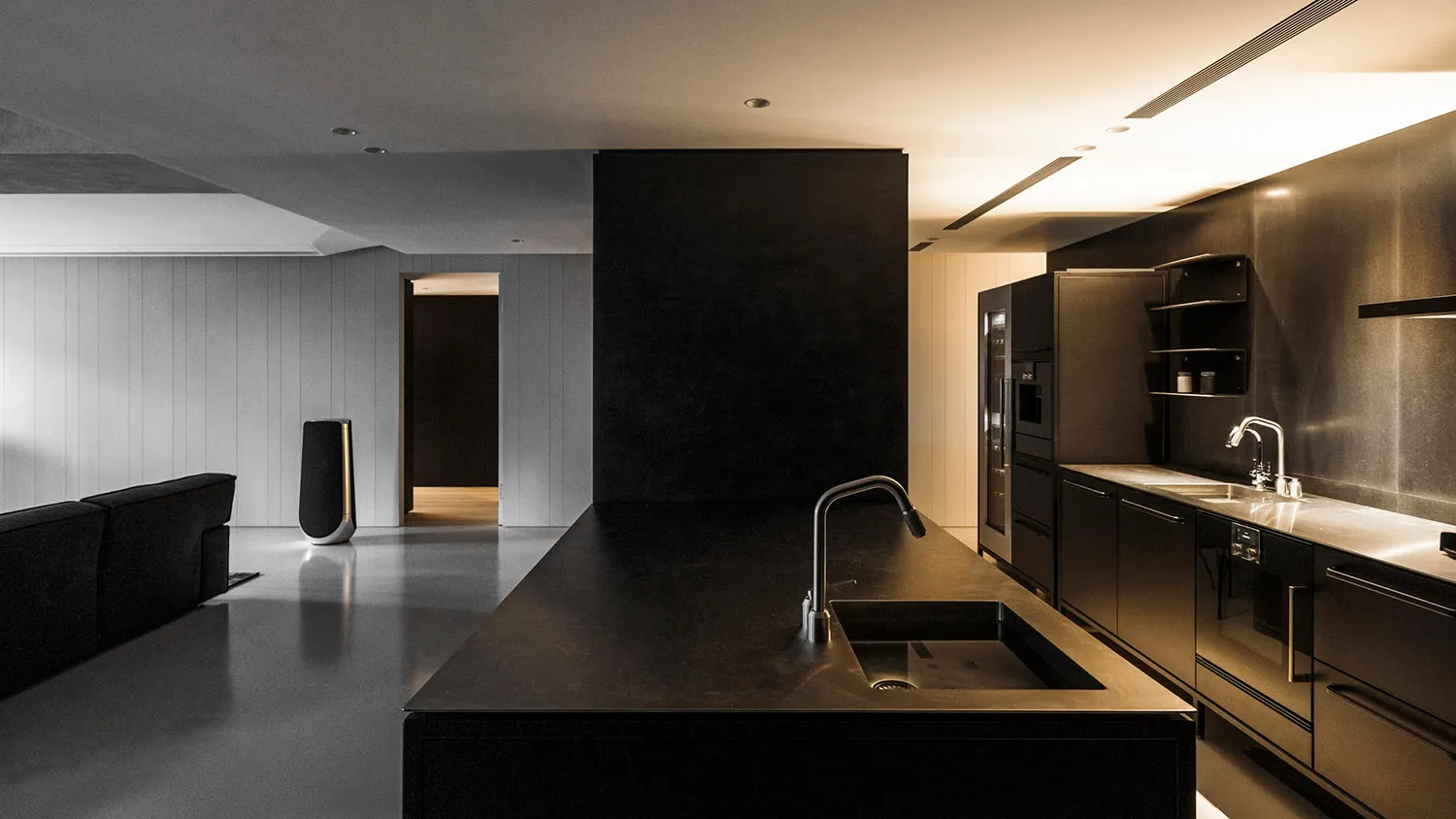 Modern minimalist kitchen featuring black granite countertops with a sleek black island.