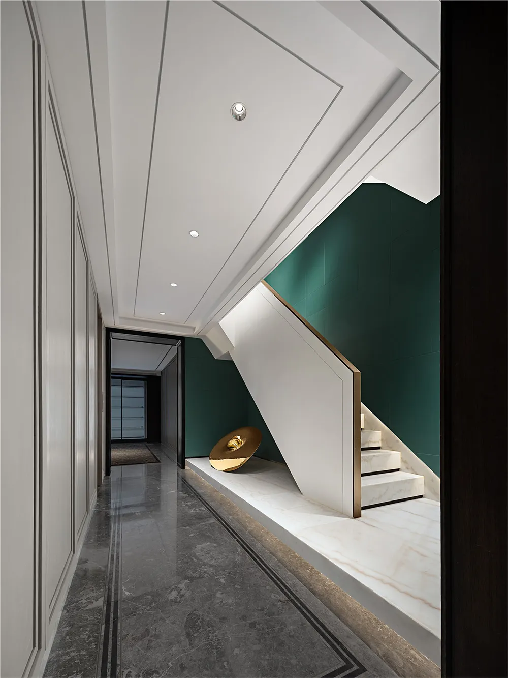 Modern, minimalist residential interior design featuring a marble staircase with a green accent wall and a minimalist art ins