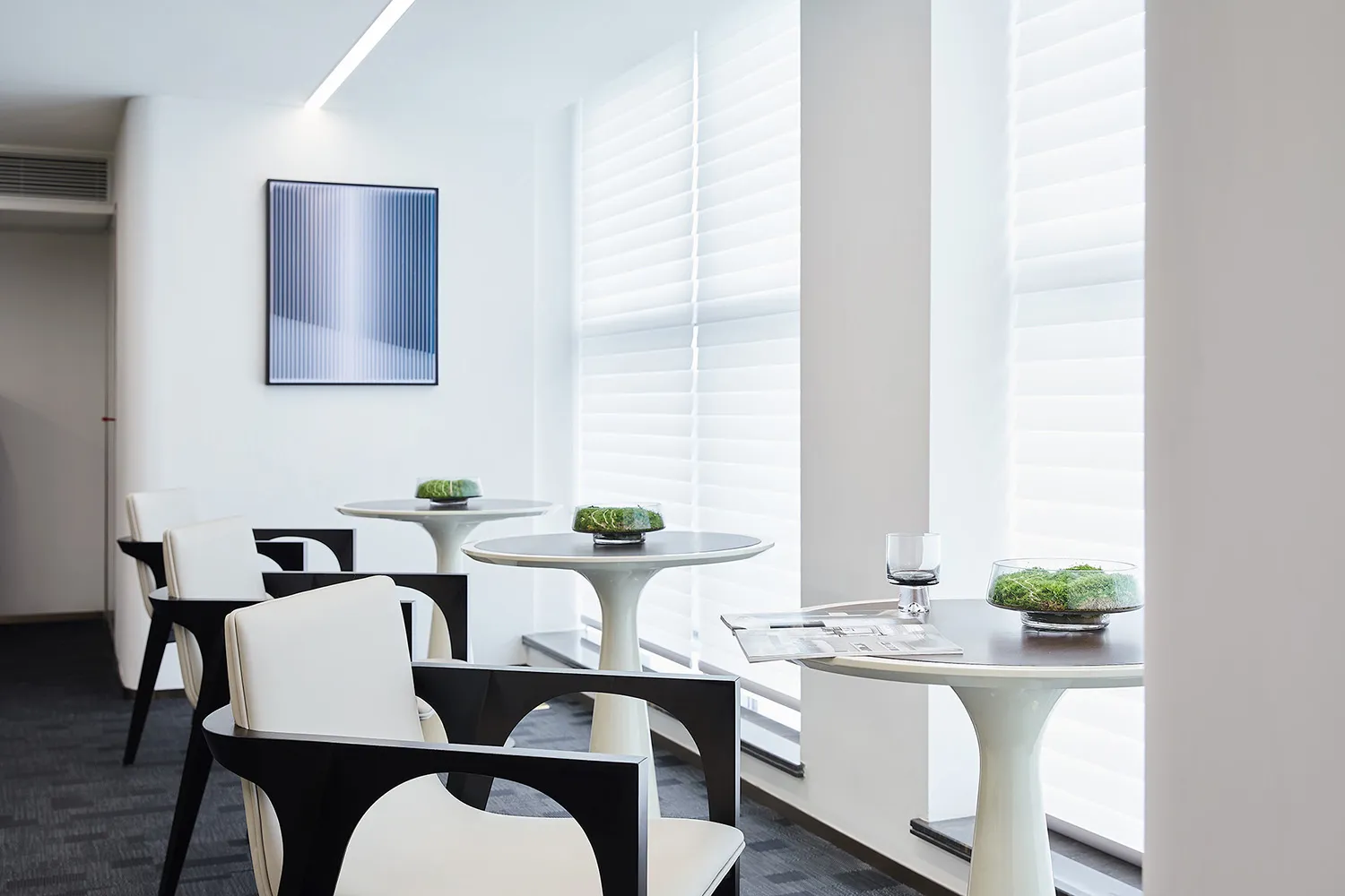 A modern coffee bar with white furniture and minimalist design.