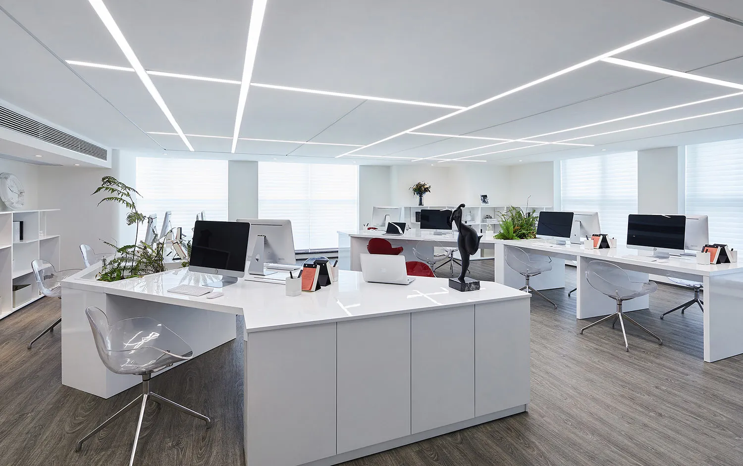 Modern minimalist office space with white furniture and glass windows.