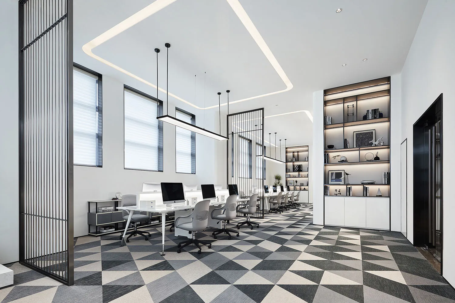A minimalist office space with white, black, and gray materials