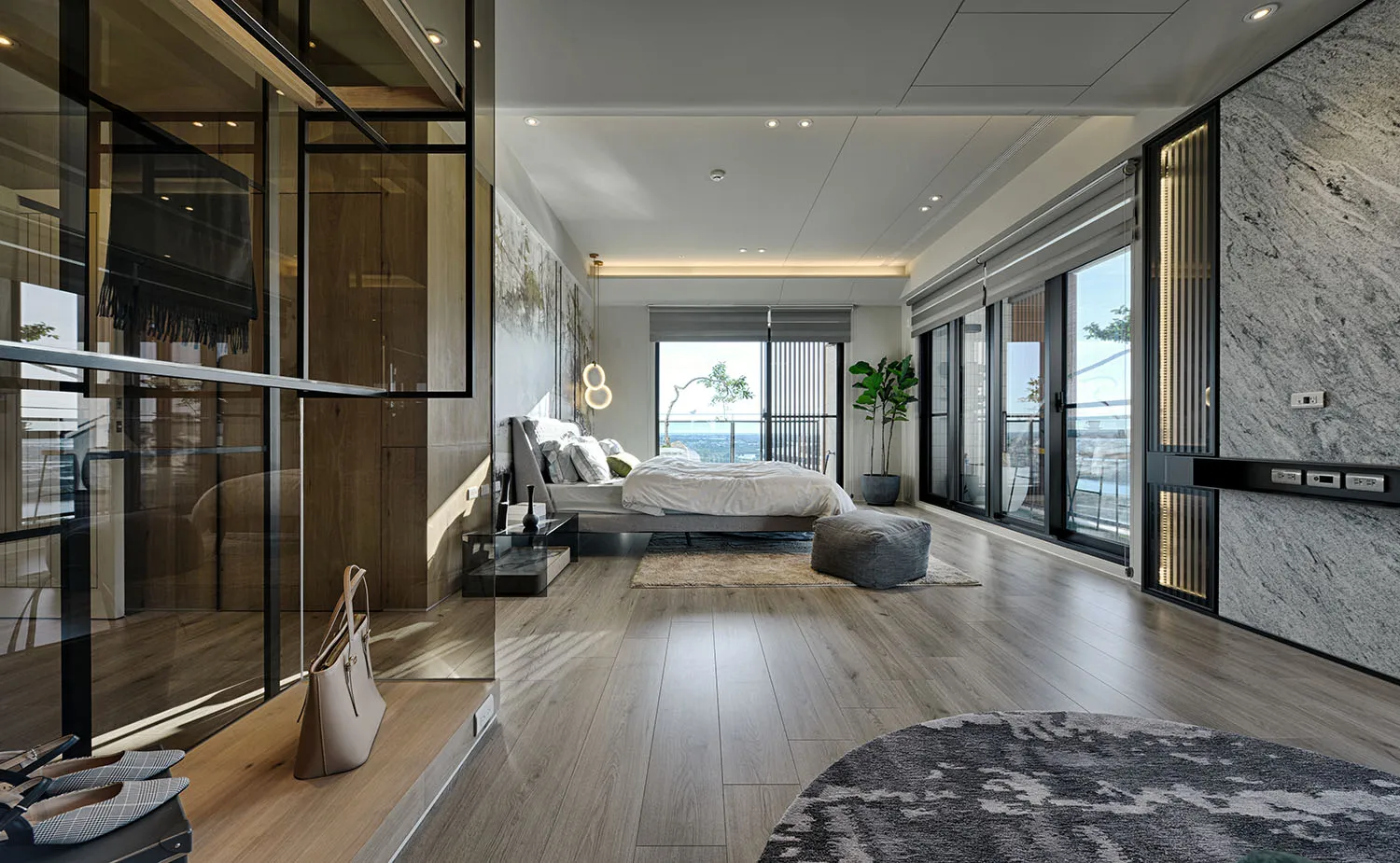 A modern bedroom with natural light from large windows, a wooden floor, and a comfortable bed.
