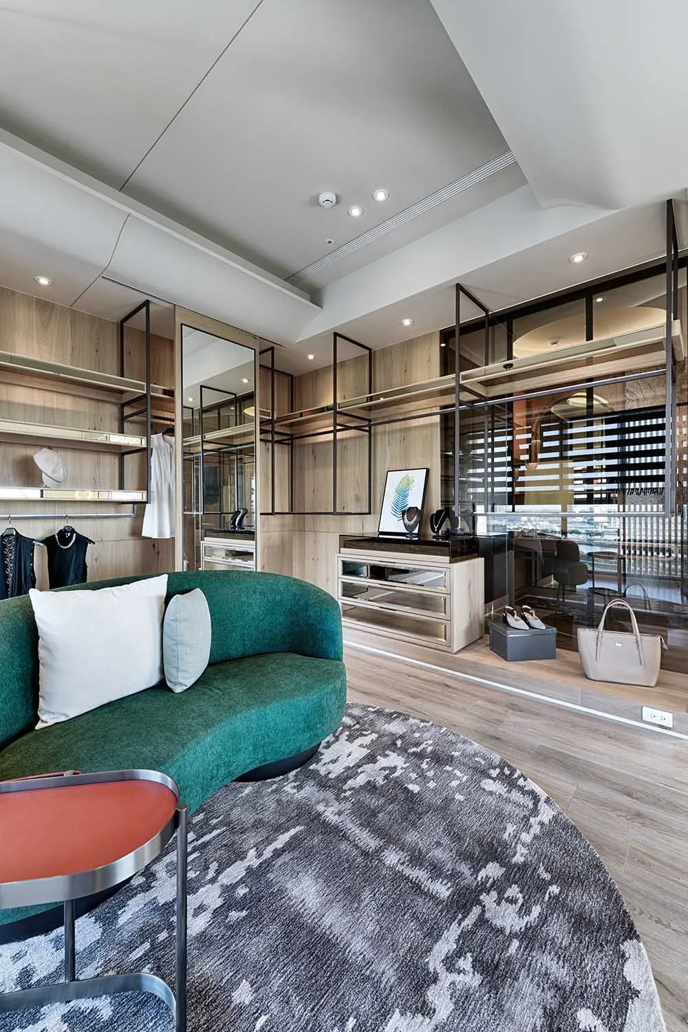 A minimalist closet space featuring wood materials and a green sofa.