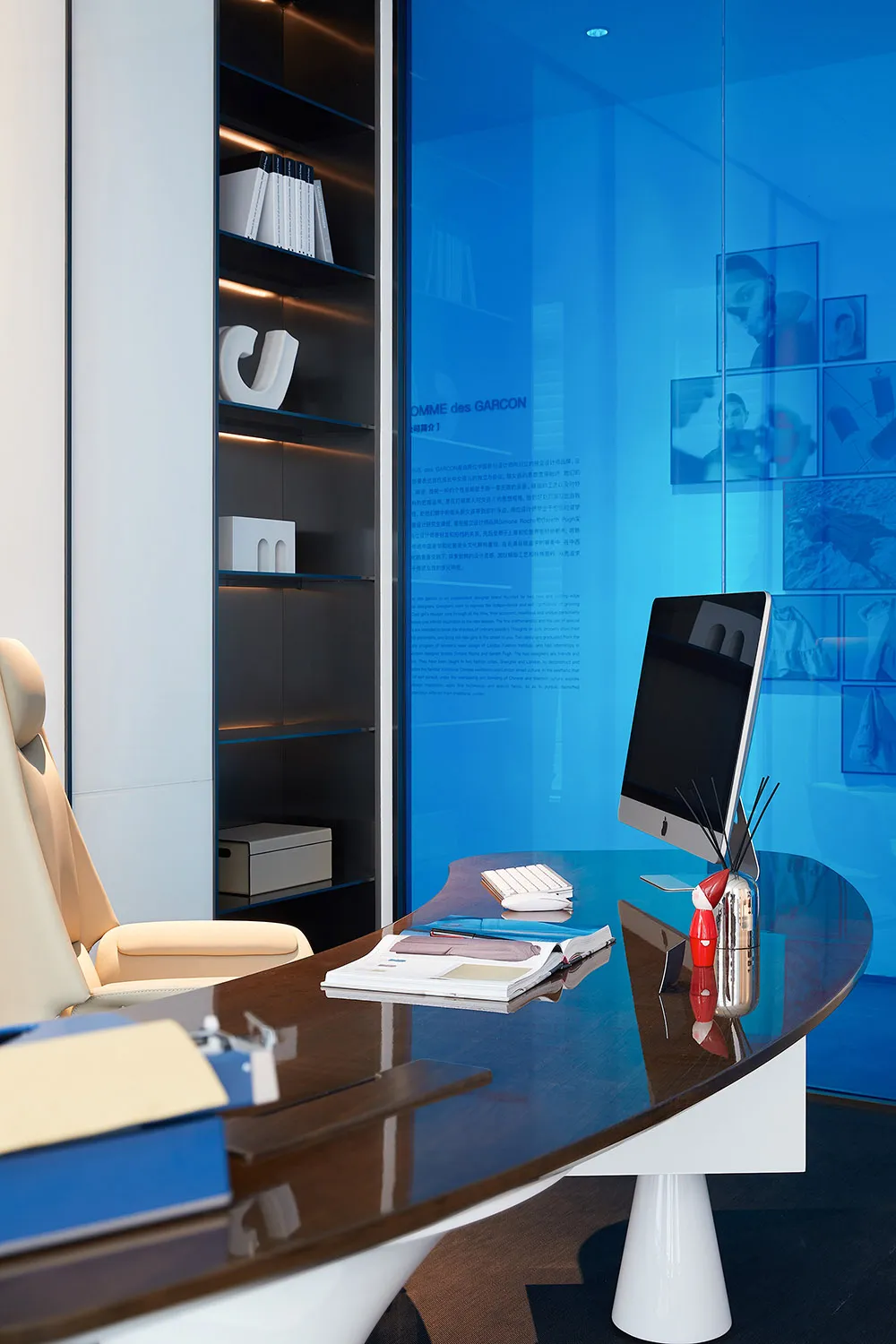 A modern office desk with a sleek, minimalist design featuring wood and glass materials.