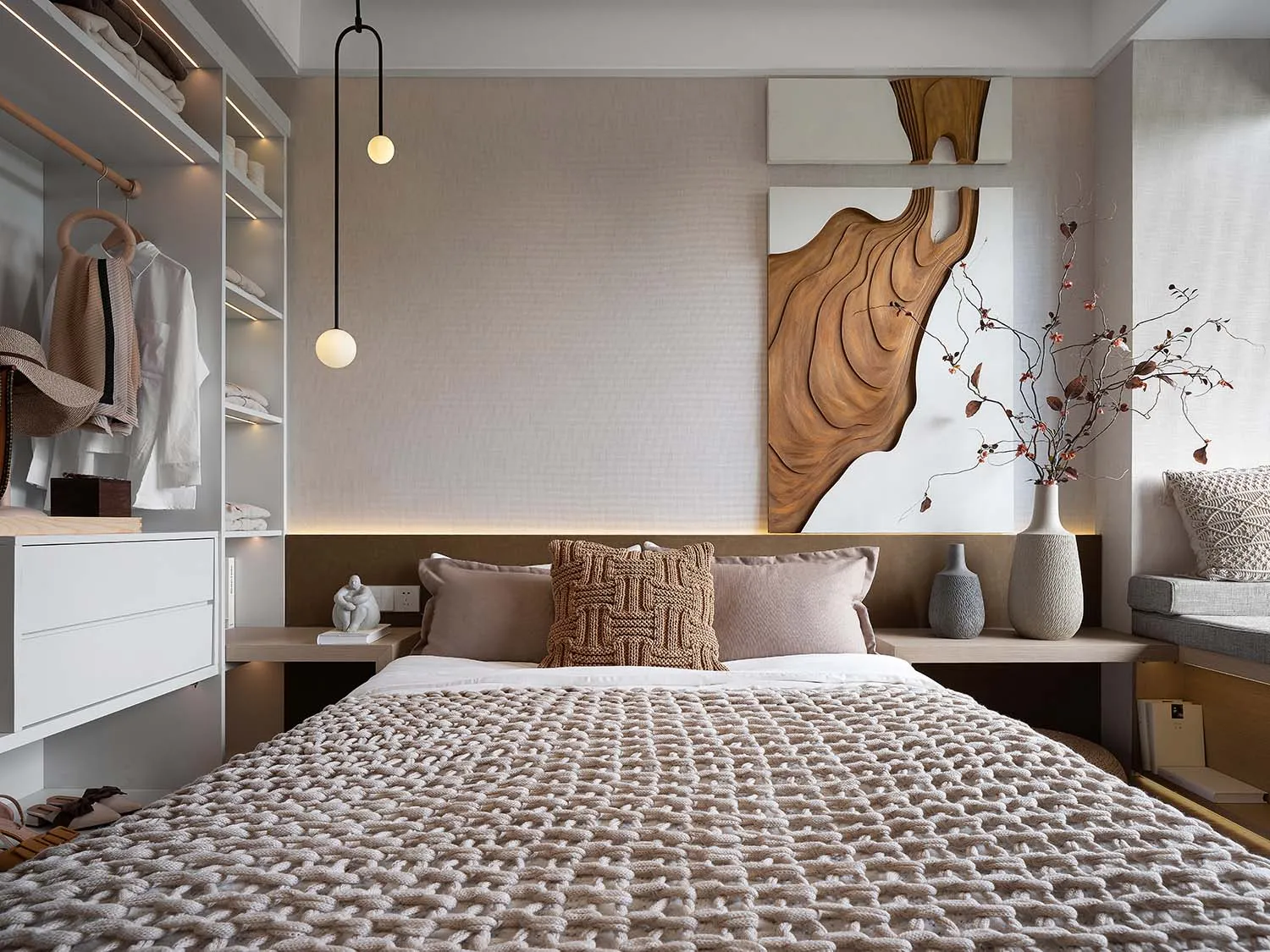 A minimalist bedroom with a warm, neutral color palette and textured bedding and decorations.