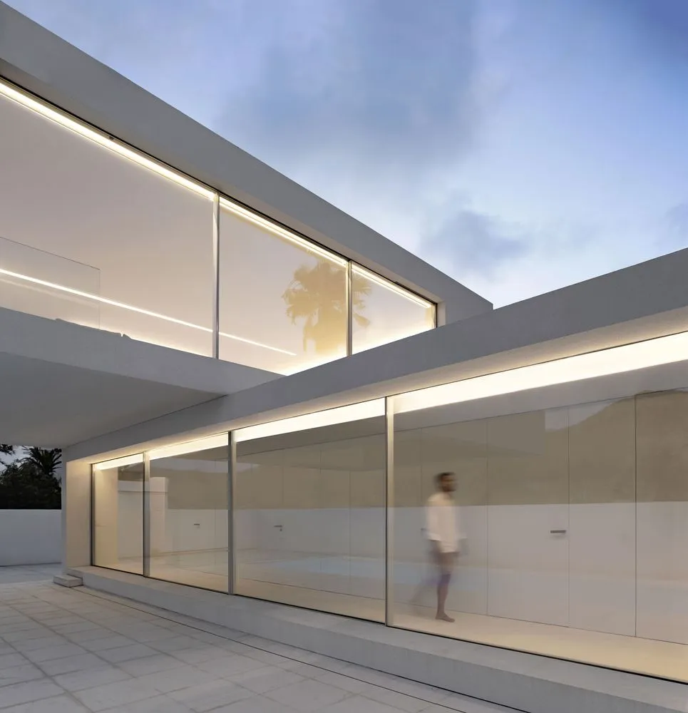 Modern residential home featuring glass and concrete materials.