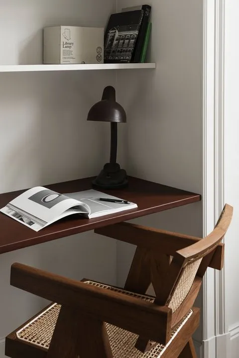 Modern home office setup featuring wooden furniture, including a desk, chair, and decorative elements.