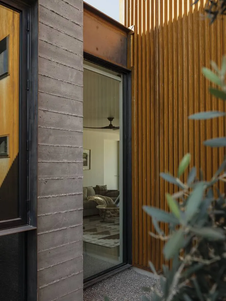 A modern residential entryway featuring concrete and wood materials.