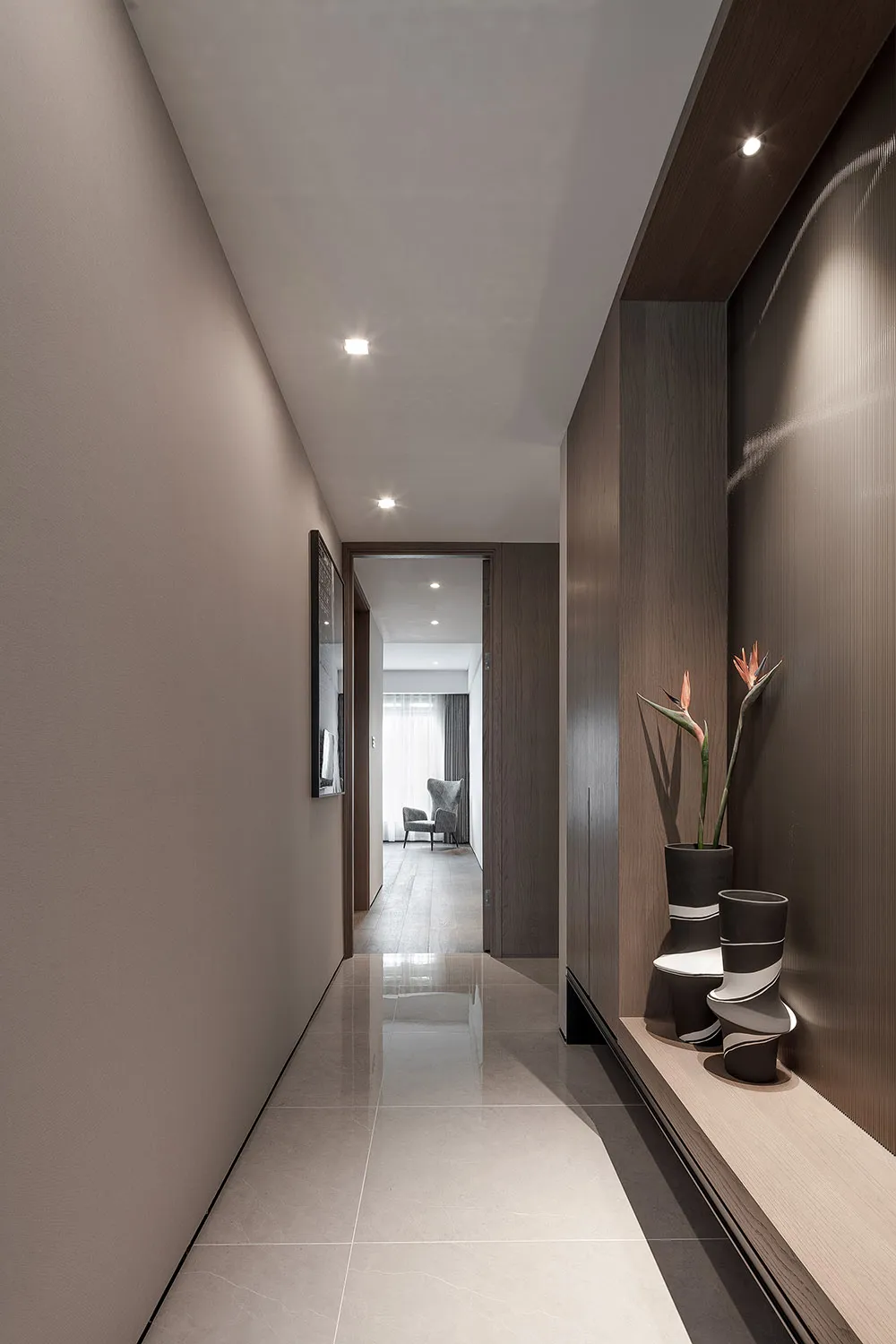 A modern, minimalist hallway with a long, narrow floor plan and a wooden wall