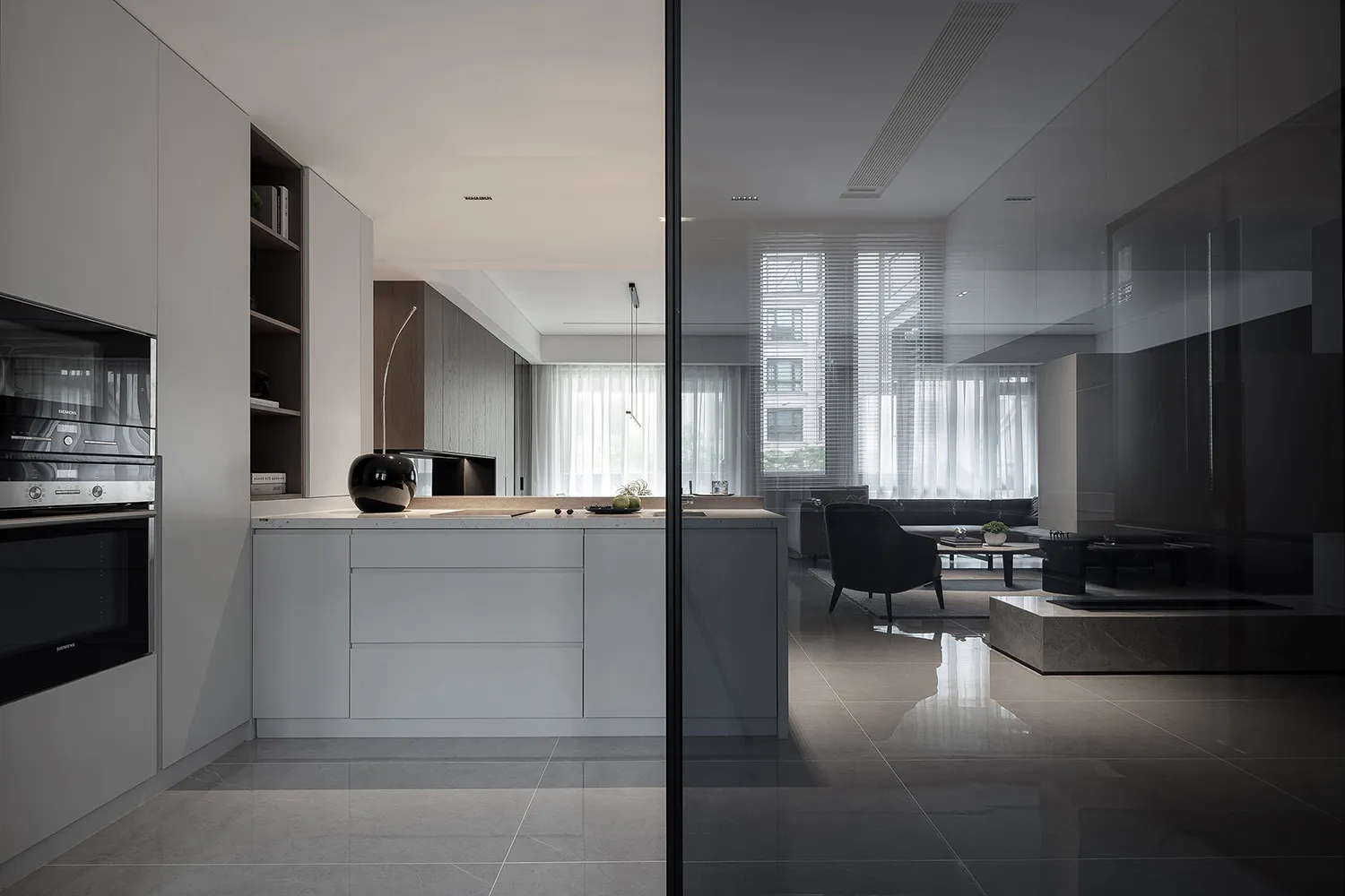 Modern residential kitchen featuring white cabinets and marble countertop.