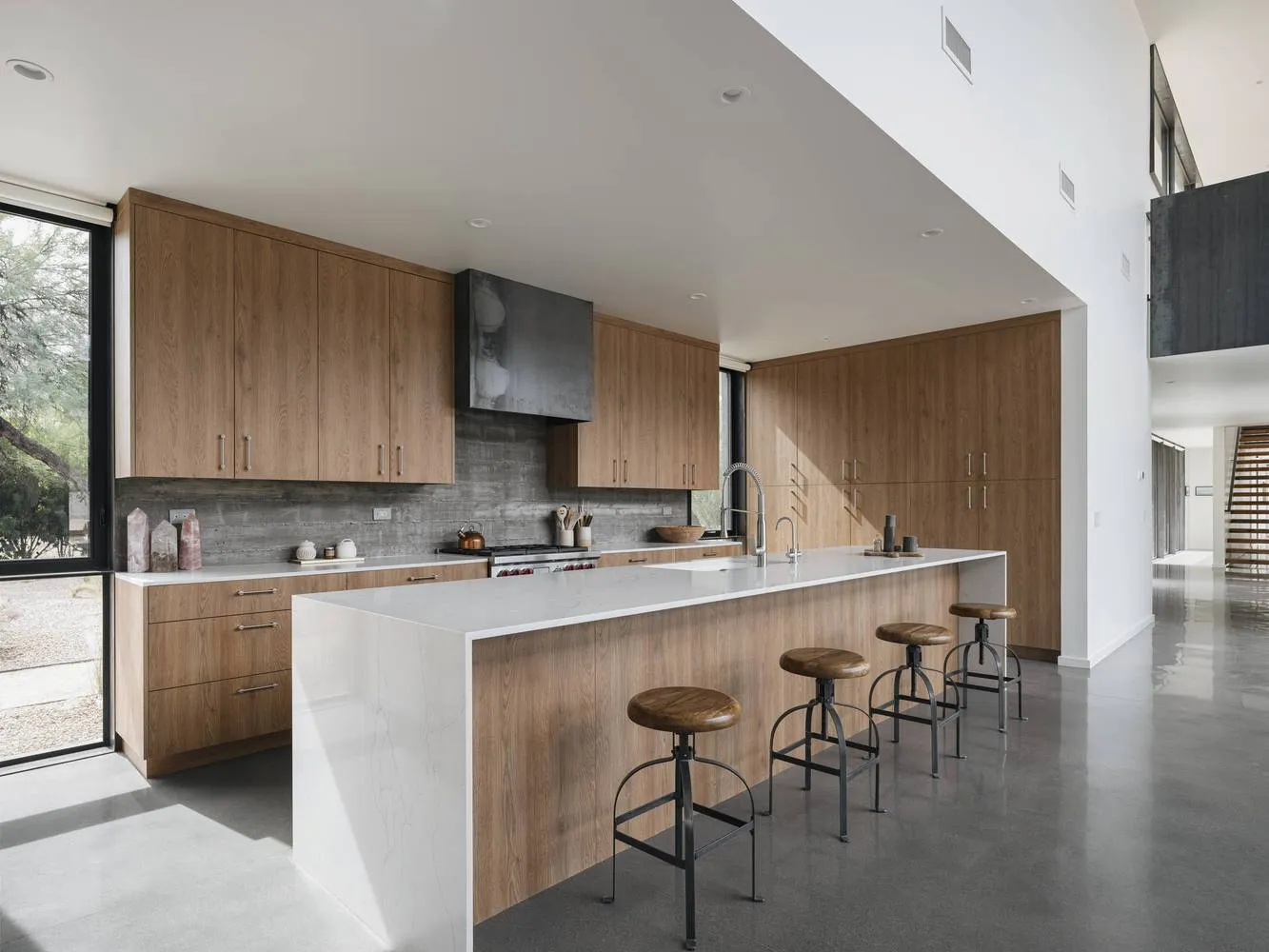 Modern residential kitchen featuring white marble countertops and wooden cabinets.