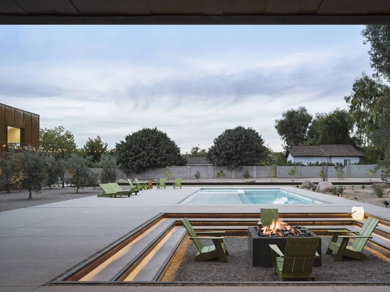 A modern residential space featuring concrete walls and illuminated concrete seating areas.